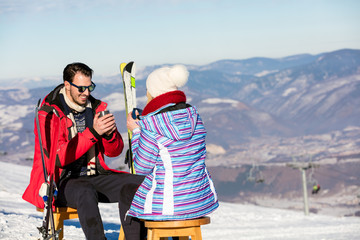 A couple is resting on lounges in picnic zone on european ski resort