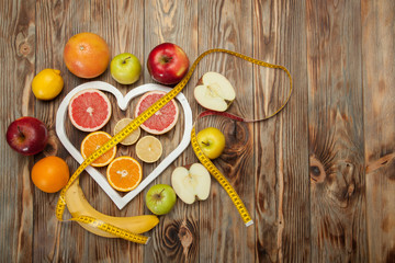 Fruit Diet, centimeter and a heart on  wooden background