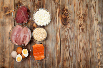 Protein diet, fish, cheese, eggs, meat and chicken wooden background