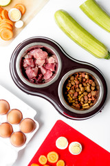 petfood set with vegetables and eggs on kitchen table background top view