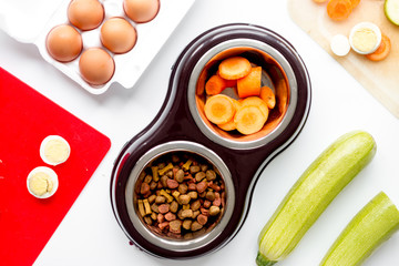 petfood set with vegetables and eggs on kitchen table background top view