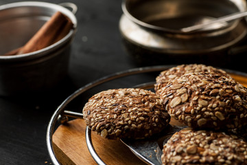 Homemade oatmeal cookies with nuts and seeds on a metal stand with other stuff, closeup shot.