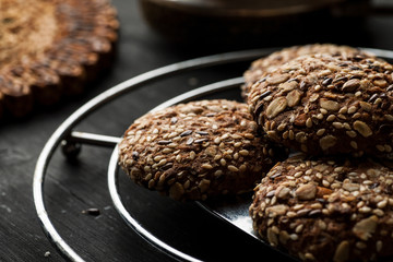 Cookies with seeds and nuts on the top on a metal stand