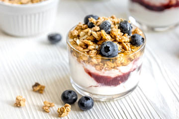 Morning granola with yogurt and berries on white kitchen background
