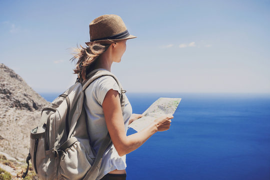 Back Side Of Traveler Girl Standing With Map And Looking At The Sea, Travel, Hiking And Active Lifestyle Concept