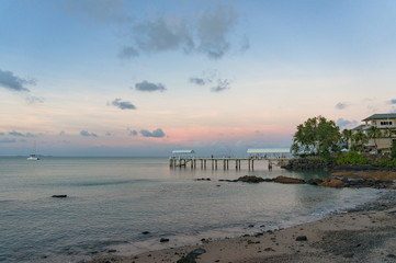 Pier, jetty, berth in tropical surroundings against sunset sky