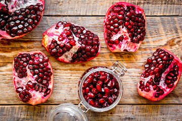 sliced pomegranate on wooden background top view