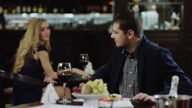 blondie beauty looking at man in restaurant and fliting