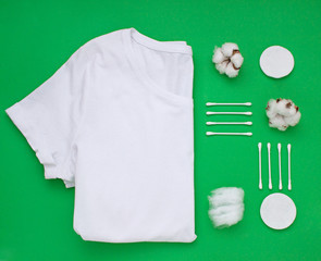 Organic white cotton flat lay on green background.. Top view composition