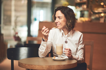 Mixed race woman in coffee shop having cofe and smiling