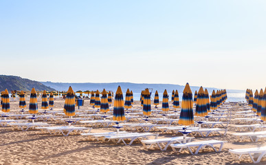 The Black Sea shore, blue clear water, beach with sand, umbrellas and sunbeds. Morning. Resort Albena, Bulgaria
