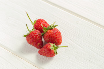 Fresh strawberries on white wooden table.