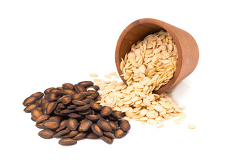 watermelon seeds  in a wooden bowl isolated on white background