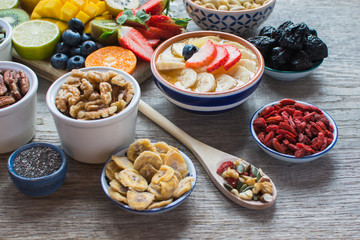 Smoothies made with satsumas, golden kiwis, mango and banana with fruits and berries on the wooden table, selective focus