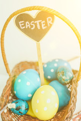 colorful easter eggs in a basket on white background