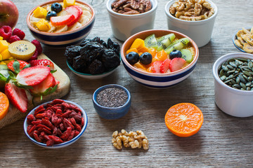 Smoothies made with satsumas, golden kiwis, mango and banana with fruits and berries on the wooden table, selective focus