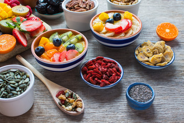 Smoothies made with satsumas, golden kiwis, mango and banana with fruits and berries on the wooden table, selective focus