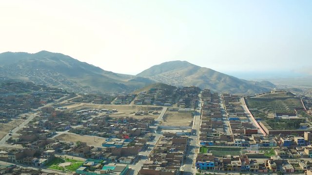 Ventanilla Peru Aerial v4 Flying low over urban poverty hillside housing area panning.