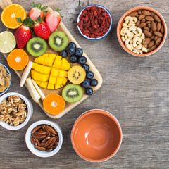 Fototapeta na wymiar Healthy and various morning breakfast selection: nuts, fruits, berries, selective focus. Top view