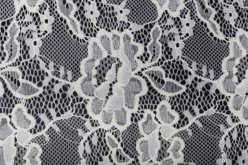 piece of white material with lace on black background