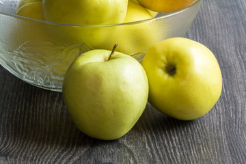 Pommes Golden devant un saladier sur fond noir