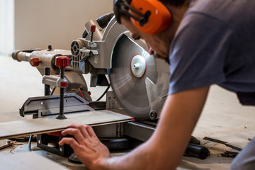 a man working with a miter saw