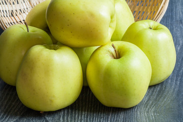 Pommes Golden en tas dans une corbeille sur fond noir