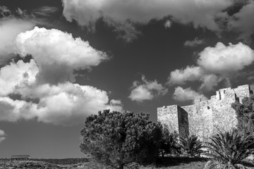 The Rocca Aldobrandesca of Talamone, Grosseto, Tuscany, Italy, against a dramatic and picturesque sky, in black and white