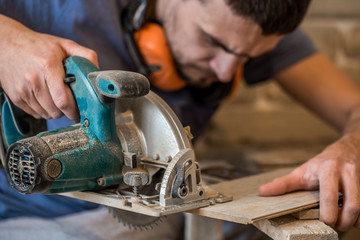 a man working with manual electric saw