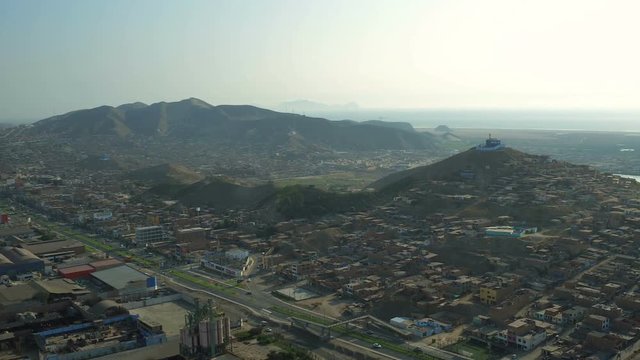 Ventanilla Peru Aerial v11 Flying low over downtown and urban poverty hillside housing area panning.