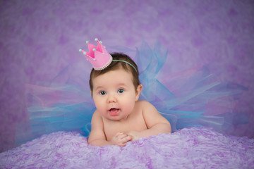 Obraz na płótnie Canvas Portrait of newborn girl smiling in a pink crown