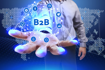 Business, Technology, Internet and network concept. Young businessman shows the word on the virtual display of the future: B2B