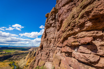 Fototapeta premium The sheer rock walls. Unusual shaped rocks on the background of blue sky. Beautiful landscape of yellow sharp cliffs. Smith Rock state park, Oregon
