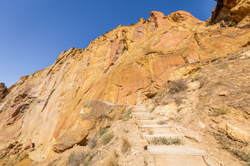 The steps for the tourists among the rocks. Unusual shaped rocks on the background of blue sky. Beautiful landscape of yellow sharp cliffs. Smith Rock state park, Oregon