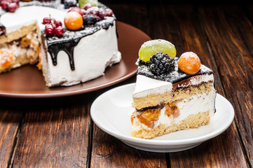 chocolate berry cake slice on plate over brown wooden background
