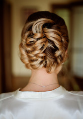 Look from behind at woman with blonde hair made up in pretty bun