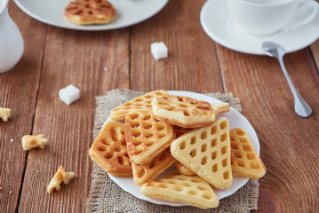Freshly baked waffles and coffee on a wooden background