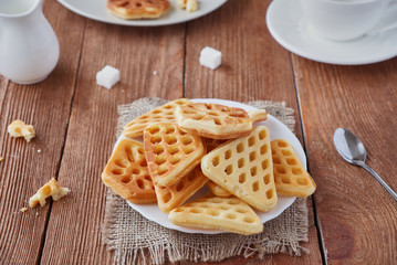 Freshly baked waffles and coffee on a wooden background