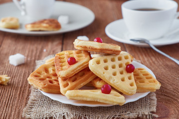 Freshly baked waffles and coffee on a wooden background
