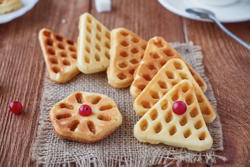 Freshly baked waffles and coffee on a wooden background