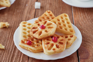Freshly baked waffles and coffee on a wooden background