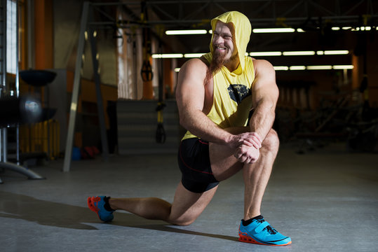 Portrait of a fitness man doing stretching exercises at gym