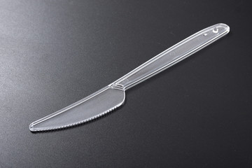 disposable plastic tableware. fork and knife on black background.