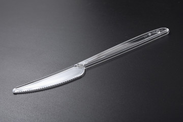 disposable plastic tableware. fork and knife on black background.