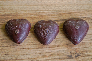 Chocolate covered gingerbread hearts on a wooden table