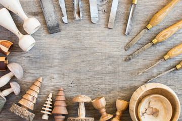 Old used chisels and wooden toys turned on the wood lathe, copy space for text, top view