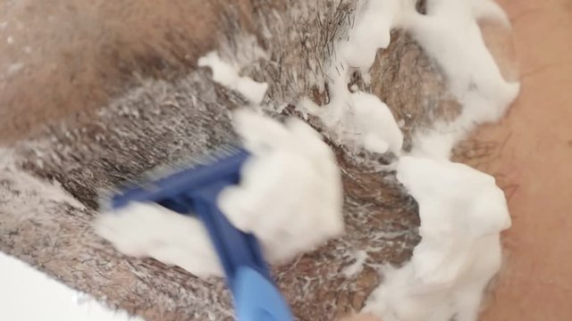 Close-up of male hand shaves foamed facial hair slow motion 1080p FullHD footage - Caucasian man uses disposable razor for shaving beard under a chin slow-mo 1920X1080 HD video 