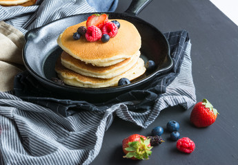 Pancakes with blueberries  & raspberry on wood background