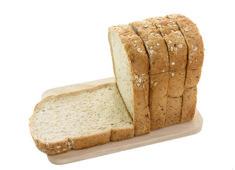 whole grain bread and slices on wooden cutting board and on white background