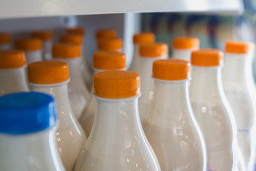 Milk bottle in a row in the supermarket, colored tube